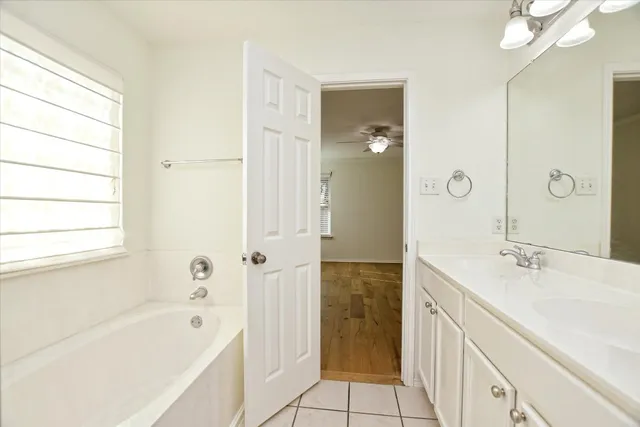 a bathroom with a tub sink and mirror