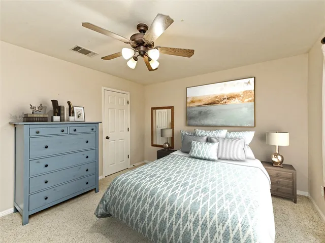 a bedroom with a large bed and a chandelier