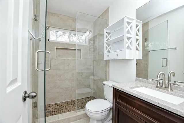 a bathroom with a granite countertop sink toilet and shower
