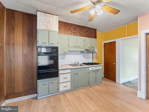 a kitchen with stainless steel appliances a stove refrigerator and cabinets