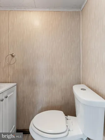 a white toilet sitting next to a white curtain and a shower curtain