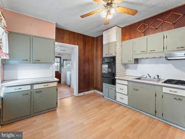a kitchen with stainless steel appliances granite countertop a sink cabinets and wooden floor