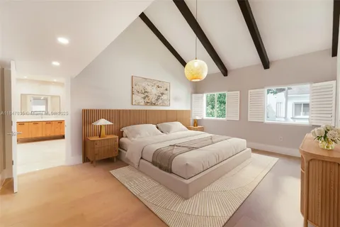 a spacious bedroom with a bed and wooden floor