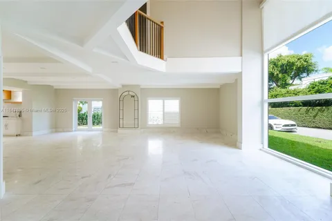 a kitchen with white cabinets and window