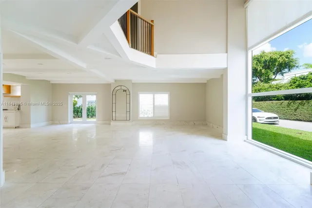 a kitchen with white cabinets and window