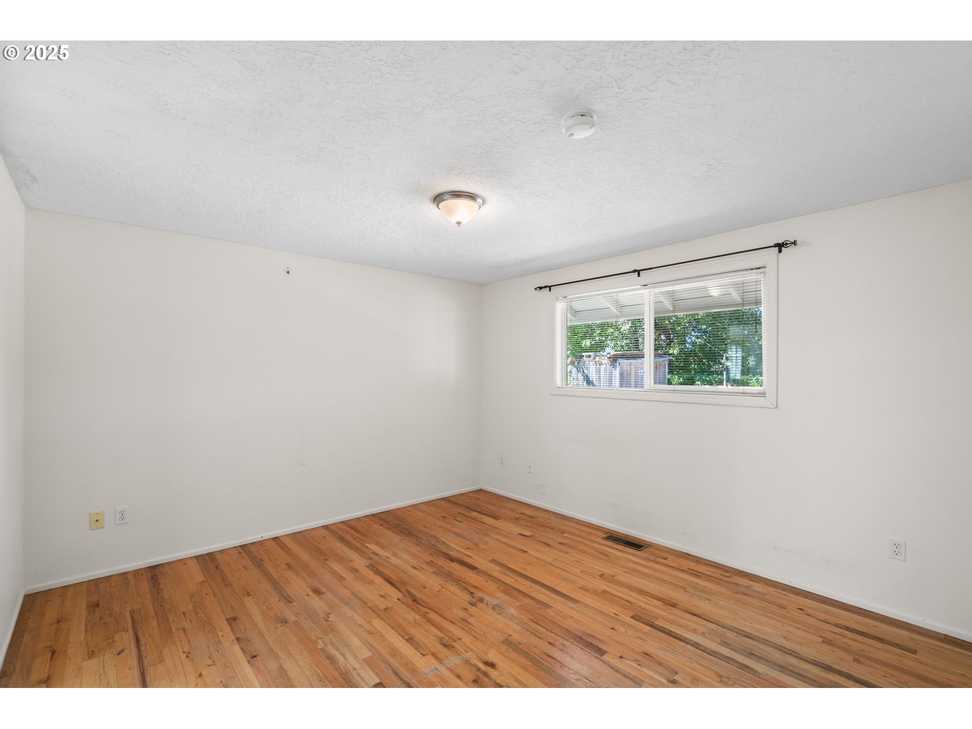 3285 Northeast 5th Street Gresham, OR 97030 - Photo 16 of 35 an empty room with wooden floor and windows