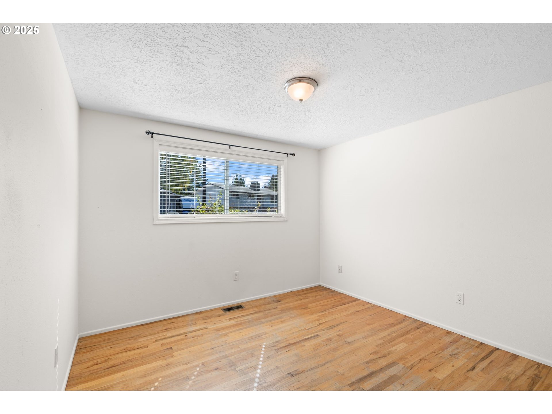 3285 Northeast 5th Street Gresham, OR 97030 - Photo 22 of 35 an empty room with wooden floor and windows