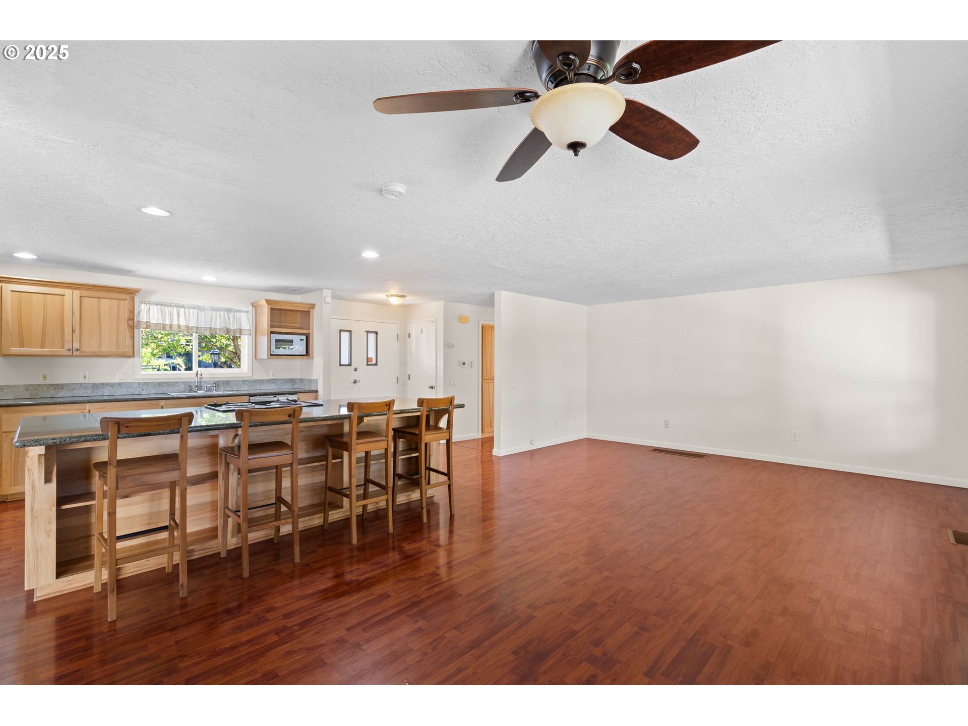 3285 Northeast 5th Street Gresham, OR 97030 - Photo 9 of 35 a view of dining room and livingroom with furniture wooden floor a rug a fireplace
