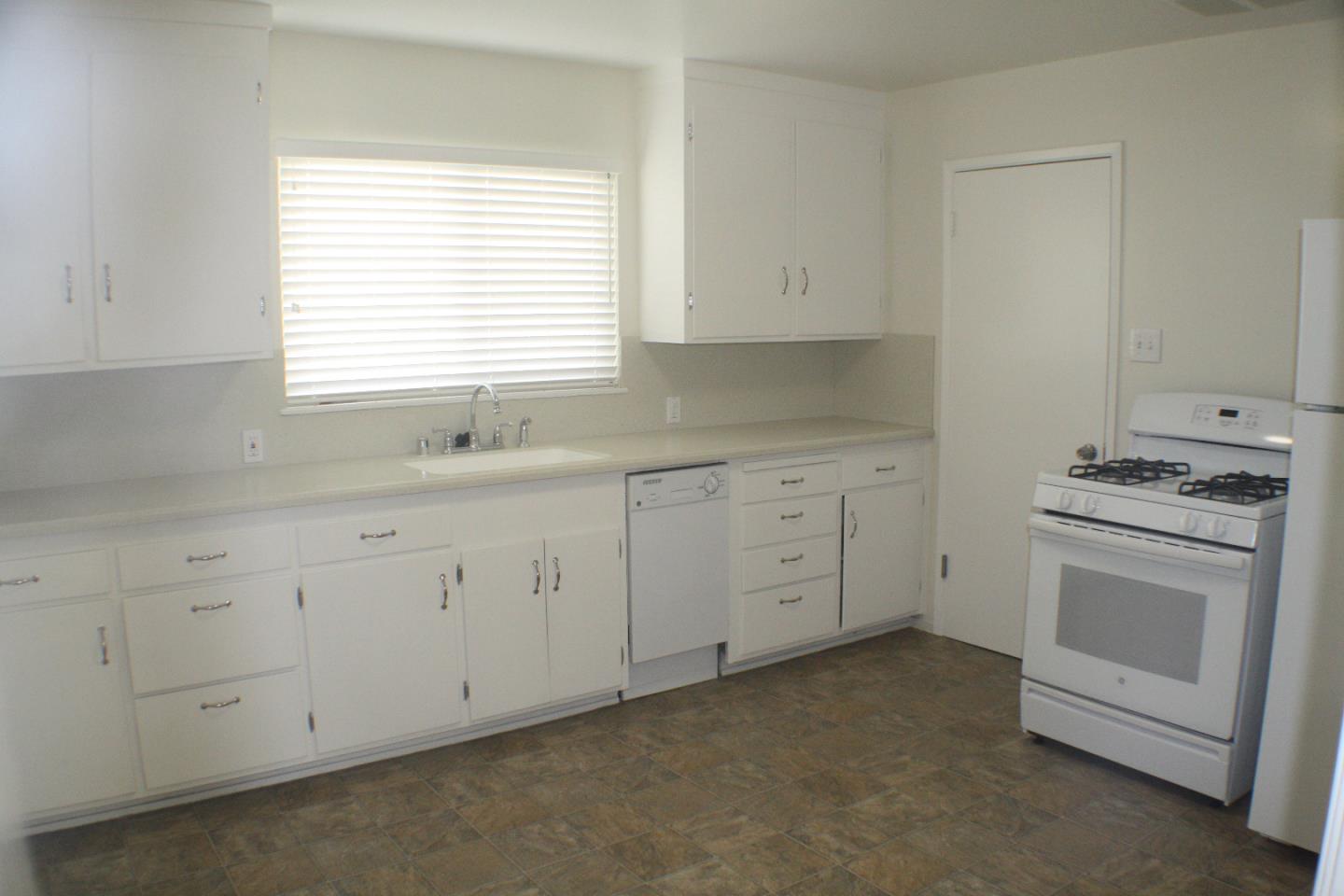 1927 Palm Avenue San Mateo, CA 94403 - Photo 15 of 19 a kitchen with white cabinets sink and window