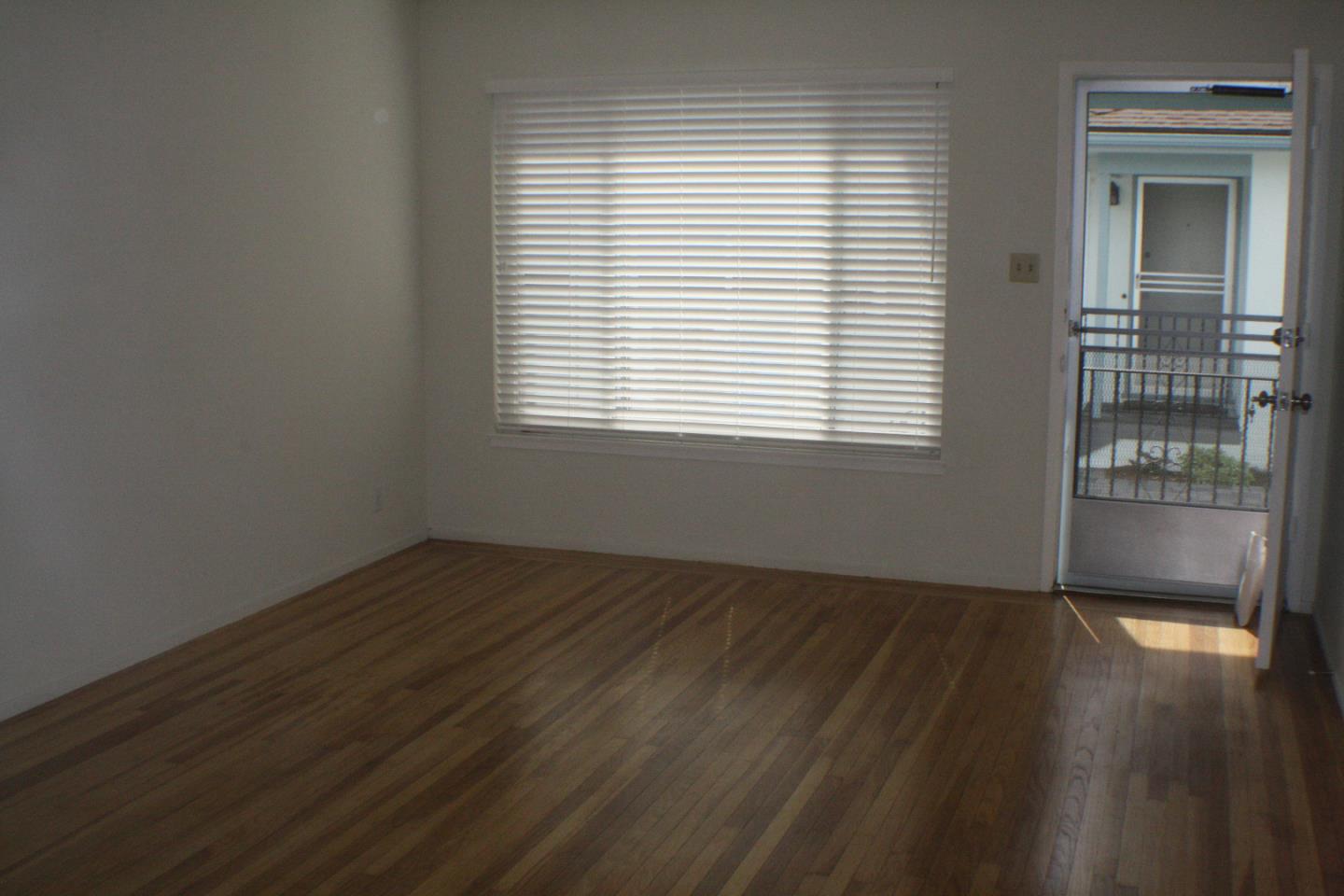 1927 Palm Avenue San Mateo, CA 94403 - Photo 16 of 19 an empty room with wooden floor and windows