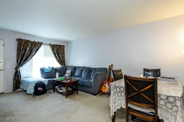 a living room with furniture a air conditioner vent and a window