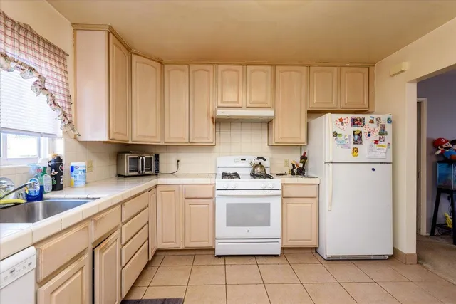 a kitchen with white cabinets stainless steel appliances and sink