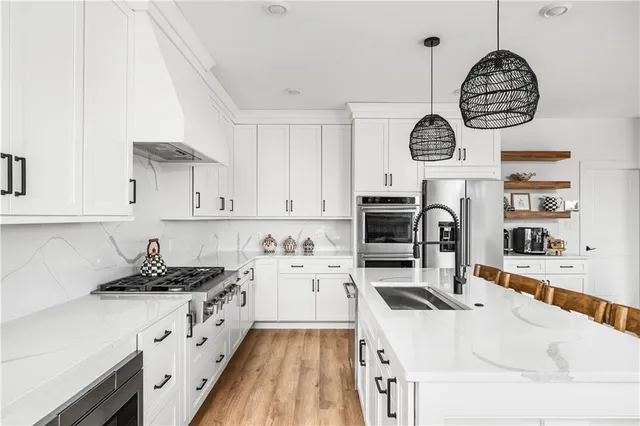 a kitchen with a refrigerator a stove top oven a clock and a window