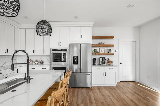 a kitchen with stainless steel appliances a stove cabinets and wooden floor