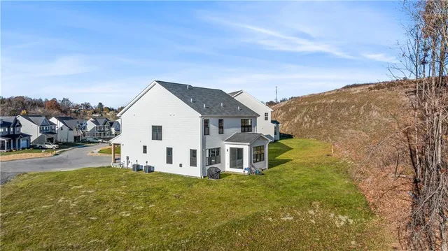 a view of a white house with a big yard and large trees