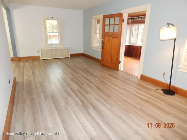 a view of empty room with window and wooden floor