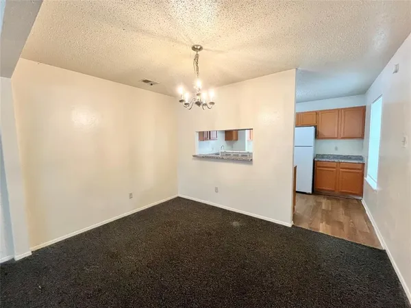 a kitchen with granite countertop a refrigerator stove top oven and sink