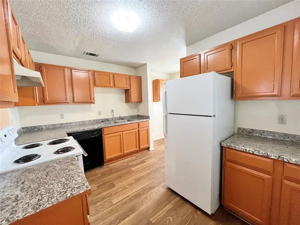 a kitchen with granite countertop white cabinets and white appliances