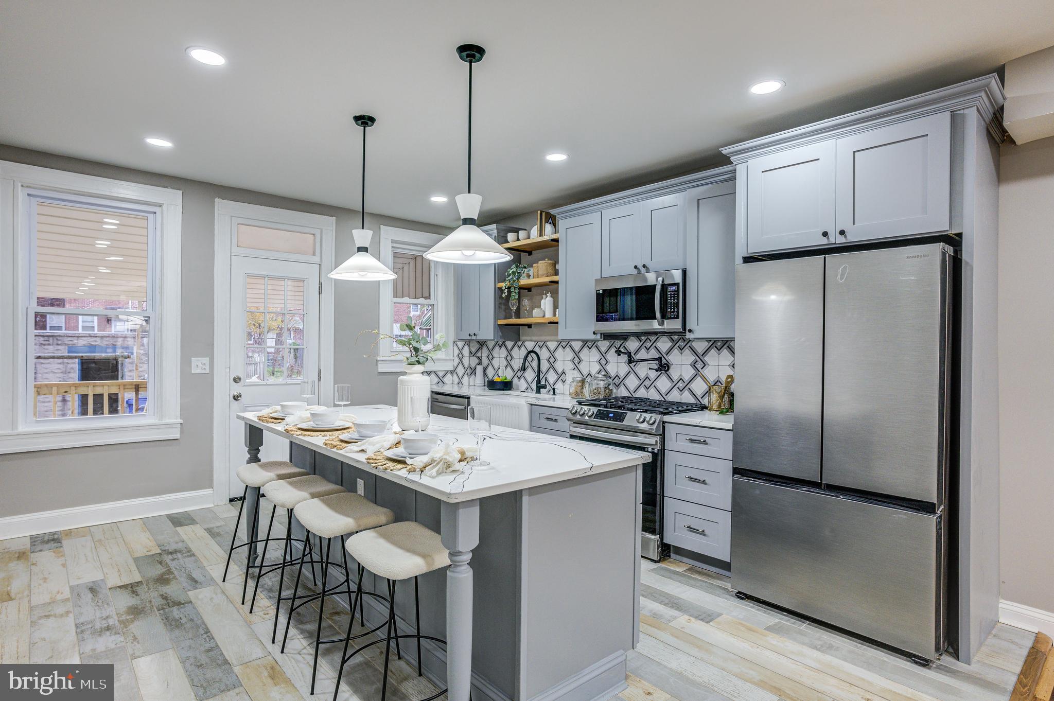 a kitchen with kitchen island granite countertop a sink a center island stainless steel appliances and cabinets