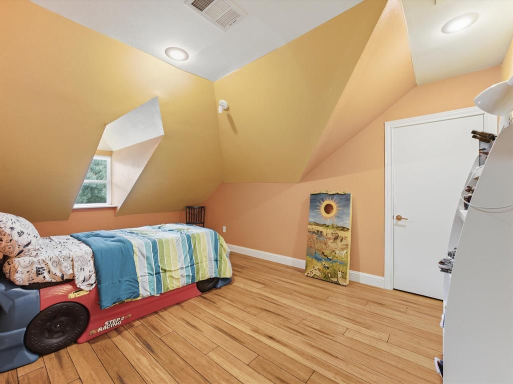 6160 Spring Valley Road Dallas, TX 75240 - Photo 32 of 40 Hardwood flooring accentuates a room with sloped ceilings and a dormer window