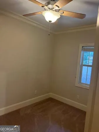 an empty room with a fan and a window