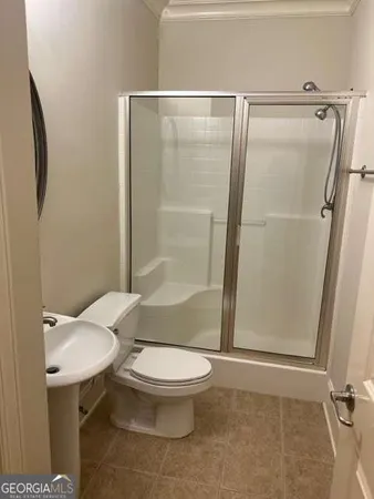 a bathroom with a shower a toilet and a sink