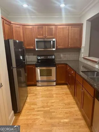 a kitchen with stainless steel appliances granite countertop a refrigerator and a stove top oven