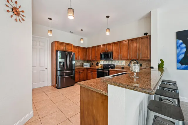 a kitchen with stainless steel appliances granite countertop wooden cabinets a sink and a stove