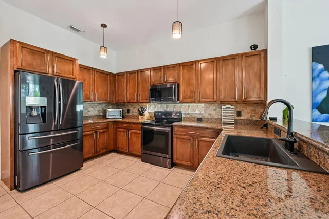 a kitchen with granite countertop a stove top oven microwave and cabinets