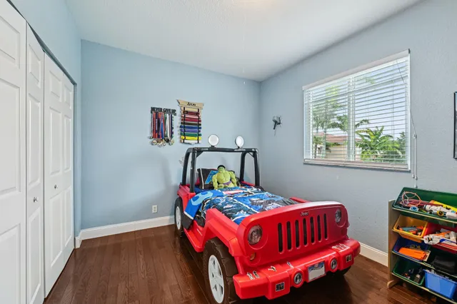 a bedroom with a bed and wooden floor