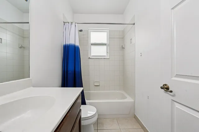 a spacious bathroom with a tub sink and mirror