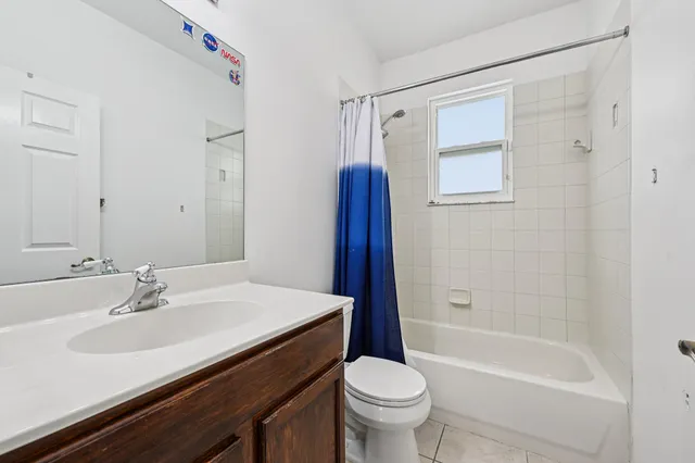 a aerial view of a house with a yard plants and large tree