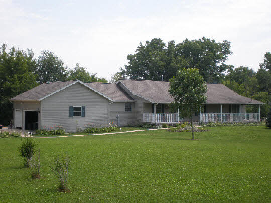 a front view of house with a garden and trees