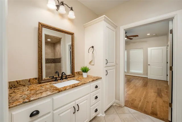 a bathroom with a granite countertop sink and a mirror