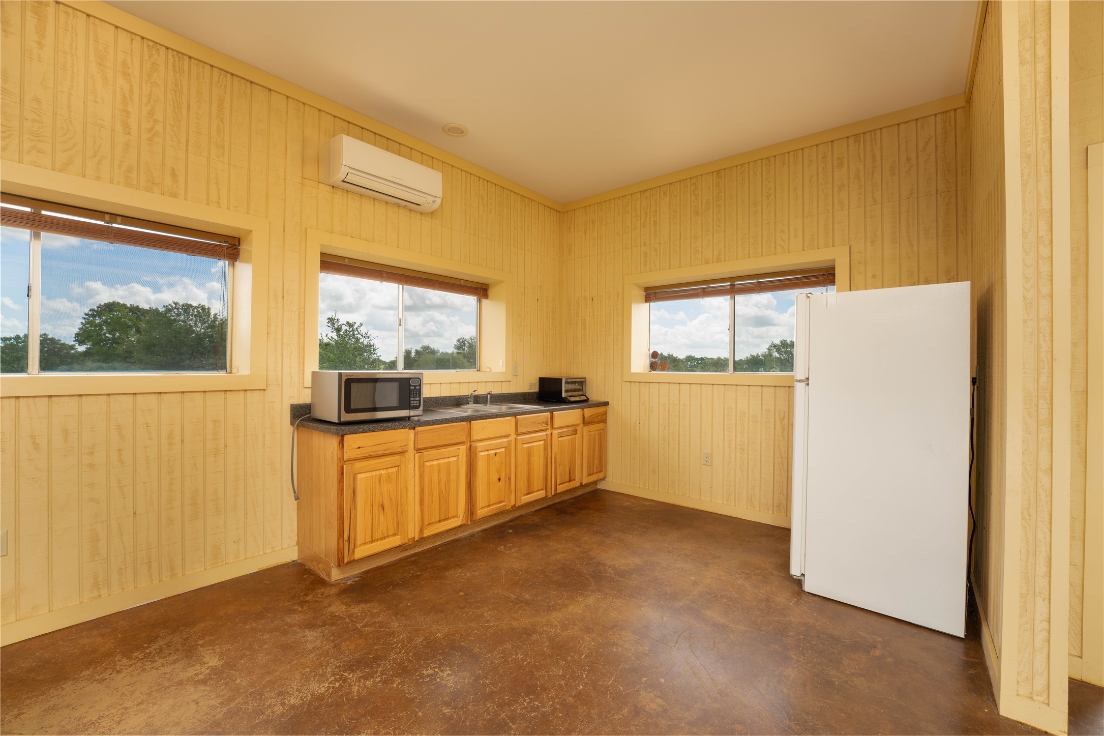 1470 South Nassau Road Round Top, TX 78954 - Photo 24 of 30 a view of a kitchen with a refrigerator a stove top oven a sink and dishwasher next to a window