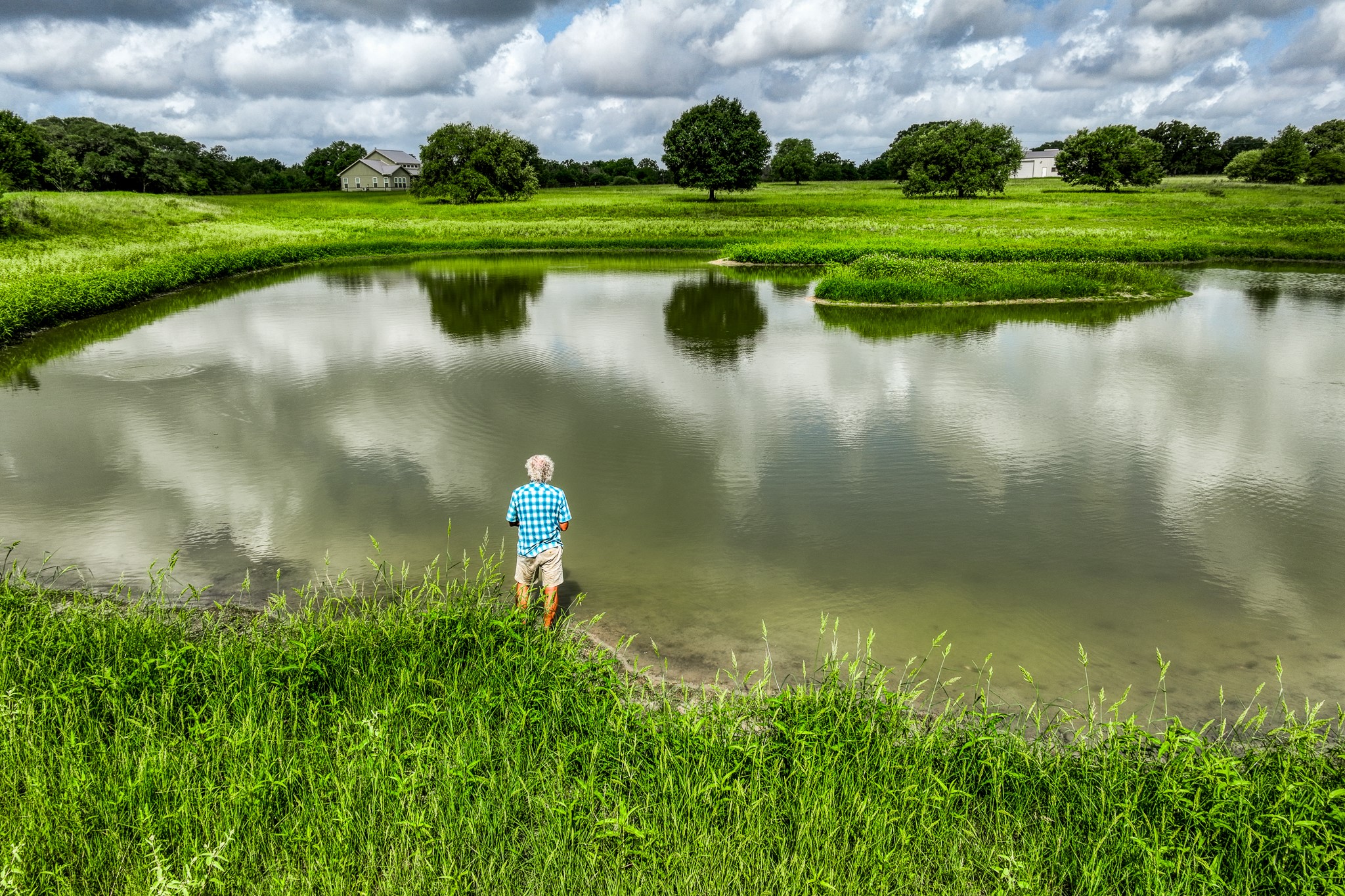 1470 South Nassau Road Round Top, TX 78954 - Photo 26 of 30 a view of a lake with a house in the background