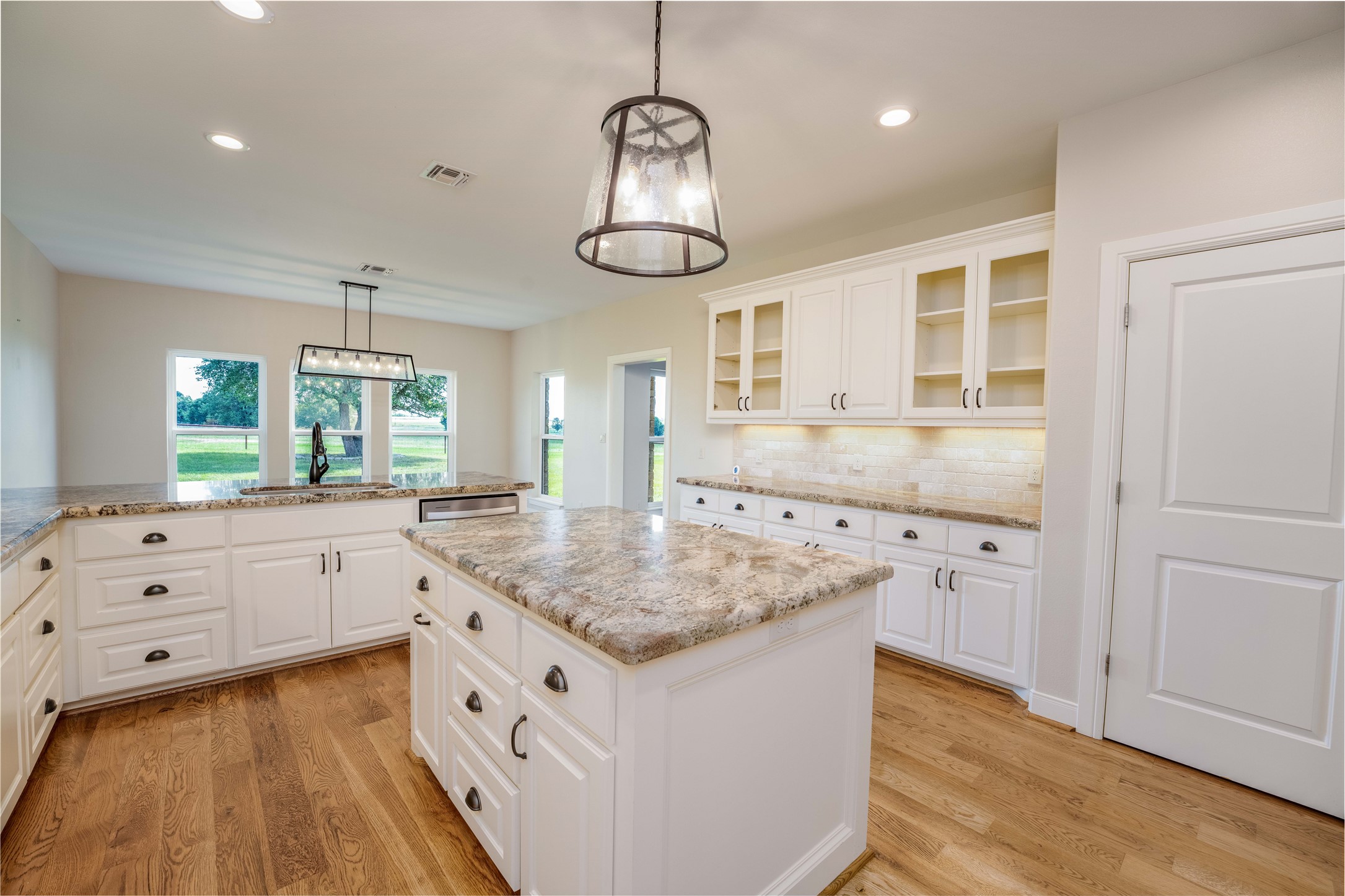 1470 South Nassau Road Round Top, TX 78954 - Photo 9 of 30 a kitchen with white cabinets and chandelier
