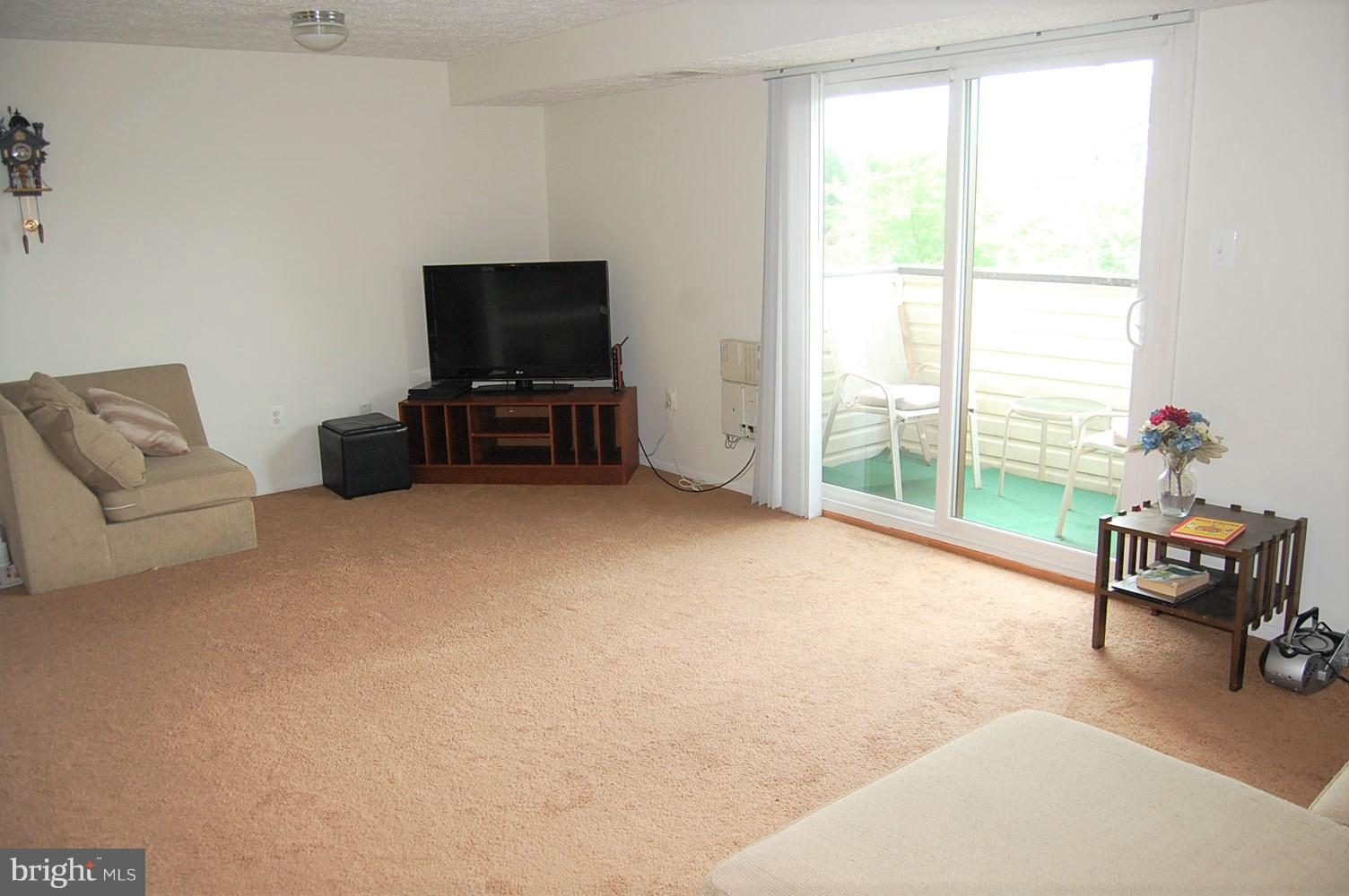 19501 Gunners Branch Road, Unit M Germantown, MD 20876 - Photo 2 of 11 a living room with furniture and a flat screen tv