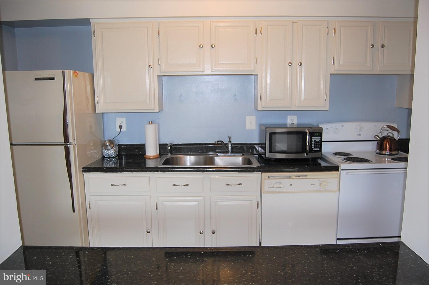 19501 Gunners Branch Road, Unit M Germantown, MD 20876 - Photo 5 of 11 a kitchen with granite countertop white cabinets and refrigerator