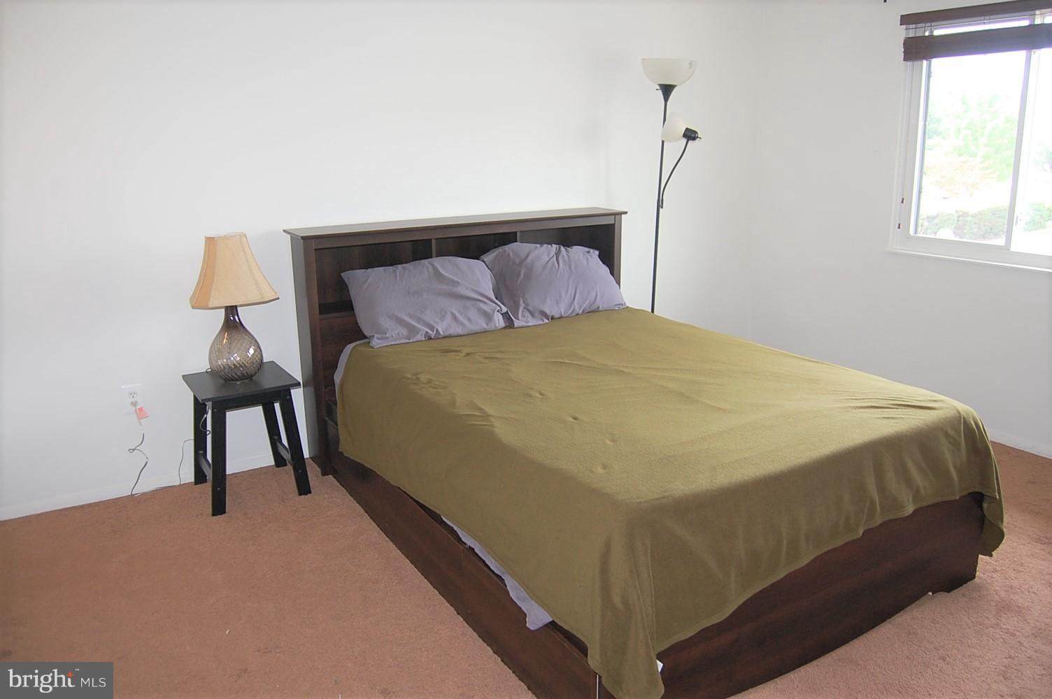 19501 Gunners Branch Road, Unit M Germantown, MD 20876 - Photo 7 of 11 a bedroom with a bed and a night stand