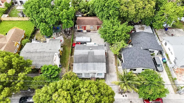 an aerial view of a house with outdoor space and a lake view in back