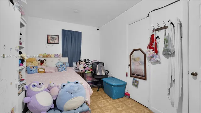 a bedroom with a bed and a potted plant on the dresser
