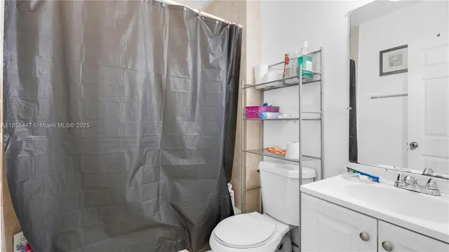a bathroom with a sink a toilet and shower curtain