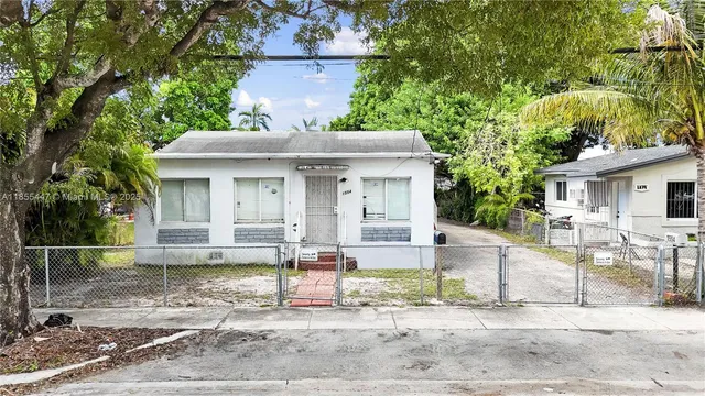 a front view of a house with a yard and potted plants