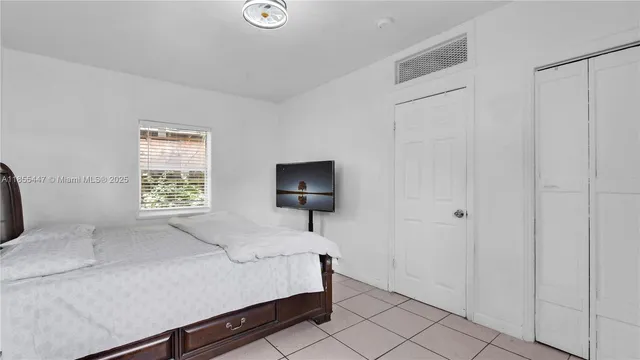 a bedroom with a bed and a lamp on the dresser