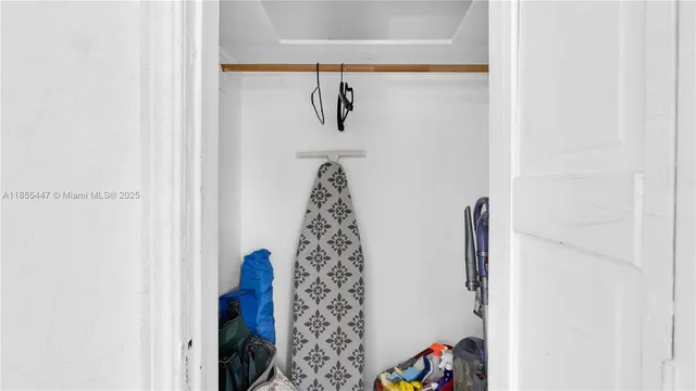 a walk in closet with wooden floor