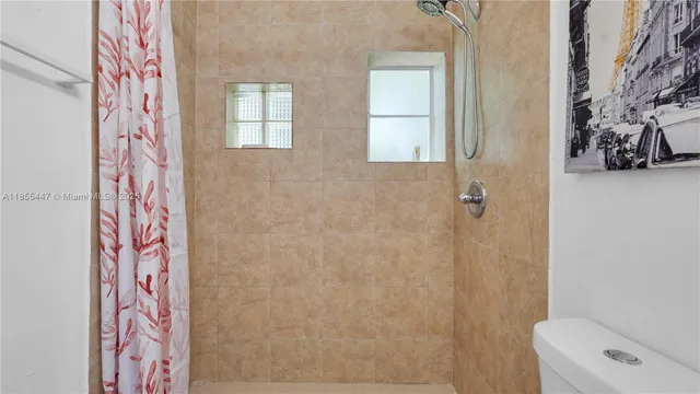 a bathroom with a toilet and a shower curtain