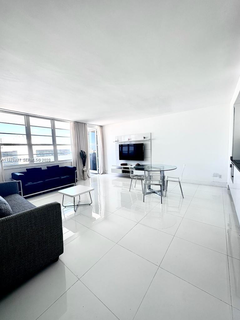 a living room with furniture a flat screen tv and a window