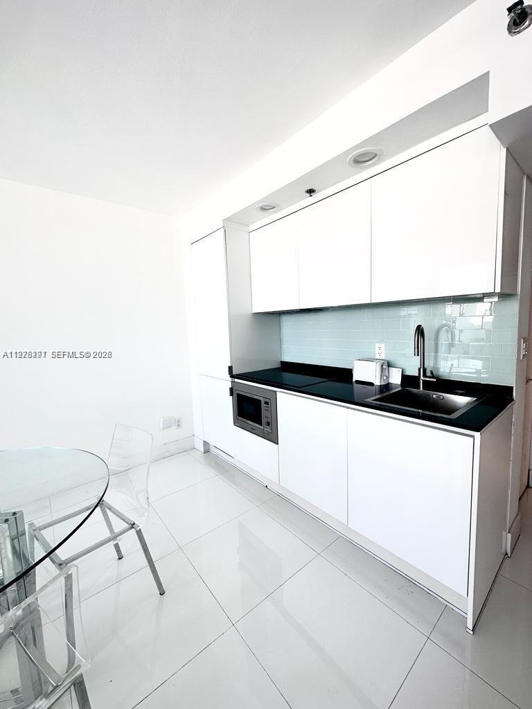 100 Lincoln Road, Unit 1404 Miami Beach, FL 33139 - Photo 11 of 18 a kitchen with granite countertop a sink and a stove