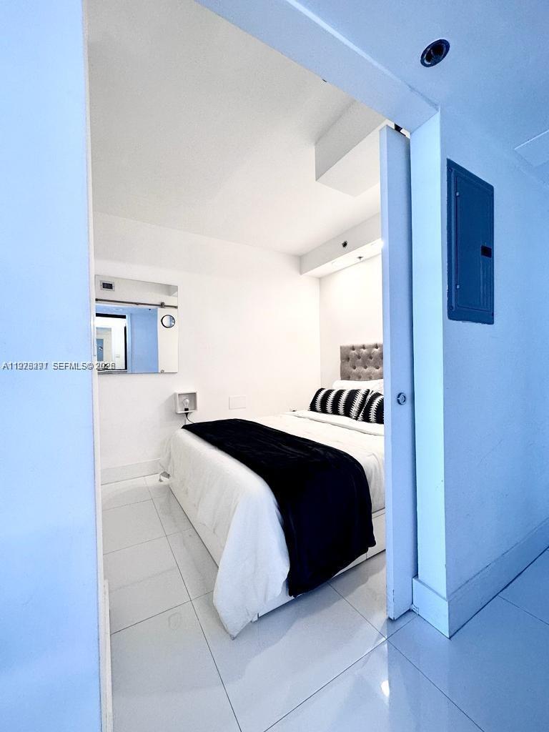 100 Lincoln Road, Unit 1404 Miami Beach, FL 33139 - Photo 5 of 18 a bedroom with a bed and a night stand